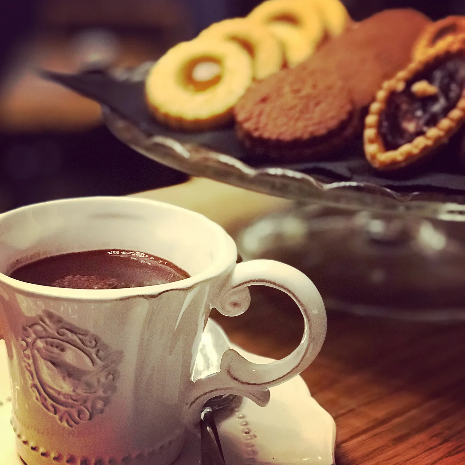 Tazza di cioccolata calda in porcellana decorata, con biscotti di pasta frolla.