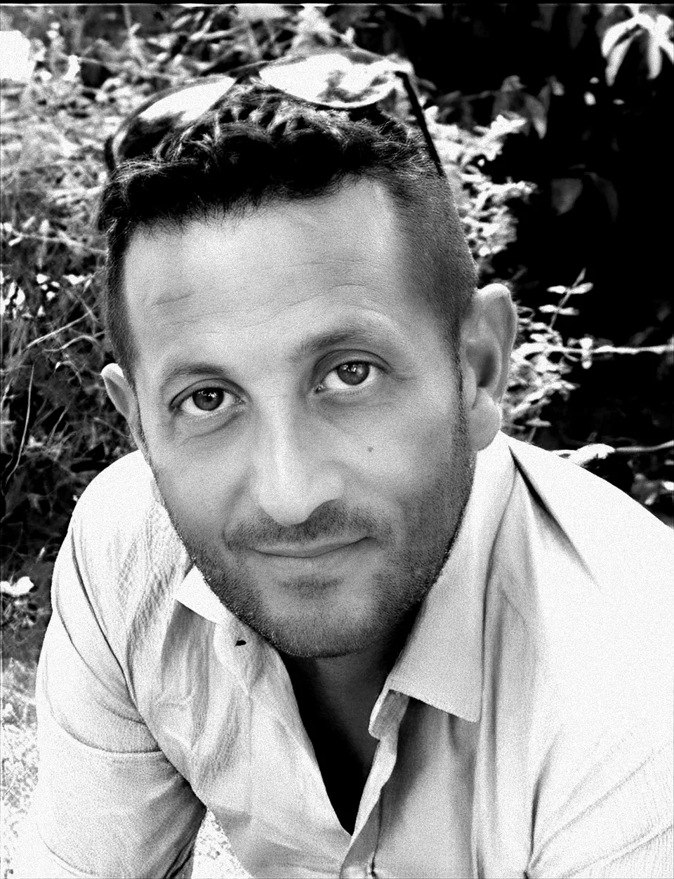 Ritratto in bianco e nero di Cosimo Gabellone, sorridente, con gli occhiali da sole sulla testa.